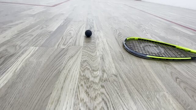 Squash racket and ball on indoor court, sports equipment close up, active lifestyle, professional sport gear, fitness training concept, healthy activity, modern squash hall interior background
