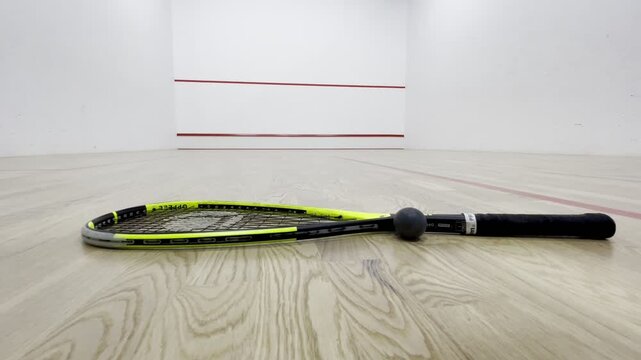 Squash racket and ball on indoor court, sports equipment close up, active lifestyle, professional sport gear, fitness training concept, healthy activity, modern squash hall interior background