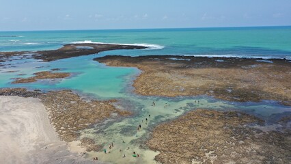 Fantastic panoramic view of Serrambi beach with coral reefs, natural swimming pools in the sea, white sand and palm trees. Serrambi near Recife in Pernambuco State, Brazil 
