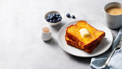 French toast with maple syrup and fresh blueberries. Light grey background. Close up. Copy space.