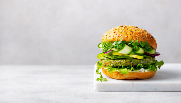 Healthy vegan burger with vegetables patty on a cutting board. Light grey background. Copy space. Close up.
