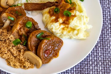 Traditional rustic Brazilian dish, beef tongue in Madeira sauce, mushrooms, rice, farofa and mashed potatoes