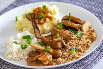 Traditional rustic Brazilian dish, beef tongue in Madeira sauce, mushrooms, rice, farofa and mashed potatoes