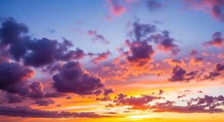 Obraz premium Vibrant Sunset Sky with Fluffy Clouds and Golden Hues.