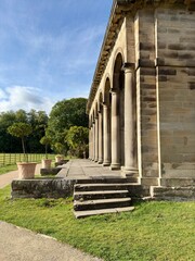 Stone columns form a classical colonnade in an outdoor setting, bathed in warm sunlight. A timeless...
