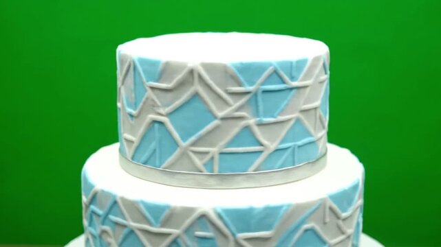 Elegant two-tier cake with geometric pattern in blue and white fondant