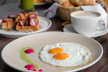 variety of breakfast items, breads, eggs, waffles, cereals, and cheeses
