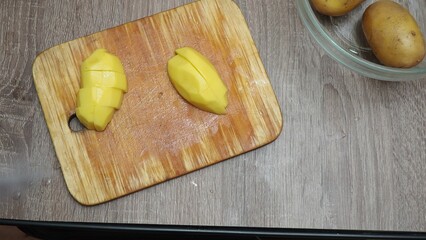 A girl peels and cuts potatoes to prepare a meal for Thanksgiving. autumn food on the table, harvest, pumpkins, grapes, corn, apples. Christmas or Thanksgiving turkey