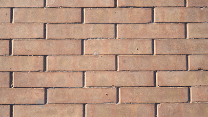 Detailed view of an old brick wall with rough mortar and aged red tones