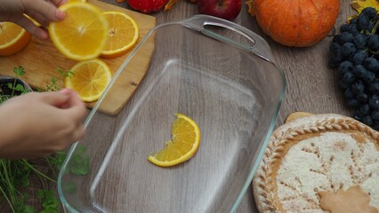 a woman is preparing a festive dinner at home. chicken with oranges. On the table there is pie and fruits, grapes, apples, pumpkin. Roasted Turkey. Thanksgiving table served . Christmas dinner