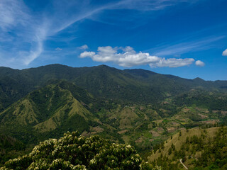 Mountains covered in lush vegetation with a river running through the valley in Gunung Nona, South...