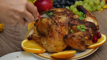 a woman is preparing a festive dinner at home. chicken with oranges. On the table there is pie and fruits, grapes, apples, pumpkin. Roasted Turkey. Thanksgiving table served . Christmas dinner