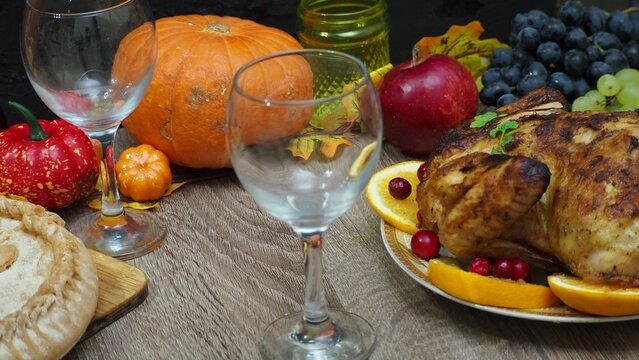 a woman is preparing a festive dinner at home. chicken with oranges. On the table there is pie and fruits, grapes, apples, pumpkin. Roasted Turkey. Thanksgiving table served . Christmas dinner - Powered by Adobe