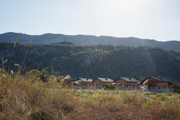 Wooden rest houses and cottages in mountains in sunlight