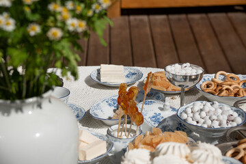 Traditional Russian sweets served on fine porcelain dishes: marshmallows, marmalade, candies, and handmade lollipops in the shape of cockerels