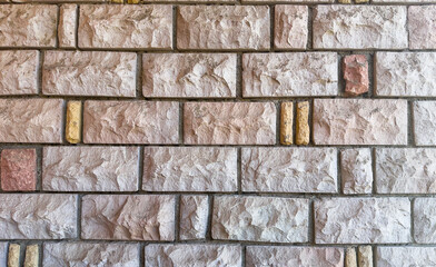 Rustic stone wall with multicolored natural rocks and mortar