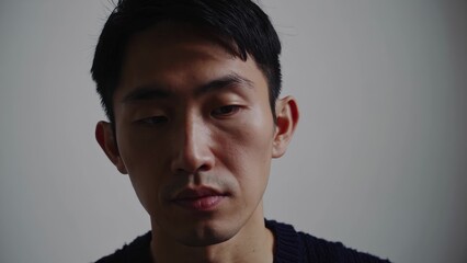 Fototapeta premium An asian man in black sweater. Portrait of man in a sweater. A casual neutral indoors isolated. A man of asian descent wearing a black sweater lifestyle.