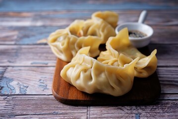 Meat dumplings with sauce on a wood cut board