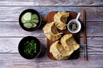Meat dumplings with sauce on a wood cut board