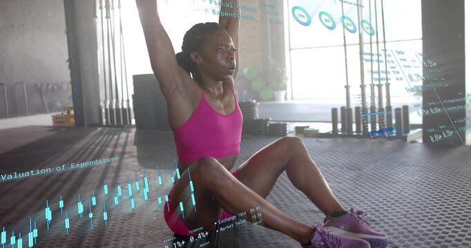 Woman gripping weight plate in gym initiating sit-up and pressing plate overhead for core strength