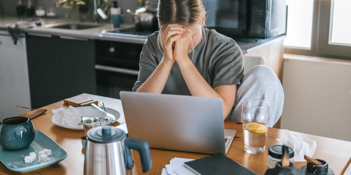  Gen Z woman working from home at cozy kitchen table with laptop and phone. Digital nomad lifestyle, mindfulness, remote work, balance, mental calm and modern freelancing