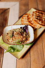 Savory dish with toast on wooden board. Pâté, puree or foie gras serving.