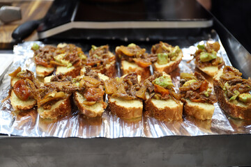 tapas aperitivos de tostas de carne y verduras con aguacate