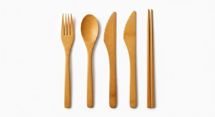 Overhead shot of a set of eco-friendly bamboo utensils, including a fork, spoon, two knives with serrated edges, and chopsticks, neatly arranged against a bright white backdrop
