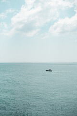 Obraz premium Exploring the serene waters of Brighton, with a small boat gliding through the calm sea on a sunny day