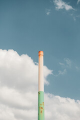 Colorful factory smokestack reaching into the blue sky with clouds in the background during a trip to the United Kingdom