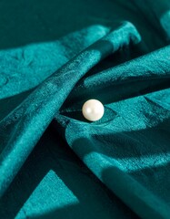 Teal fabric draped, single pearl
