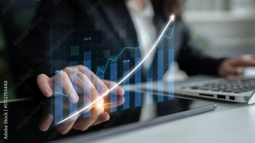 Poster a business professional using a tablet to analyze digital graphs and trends in a modern office envir