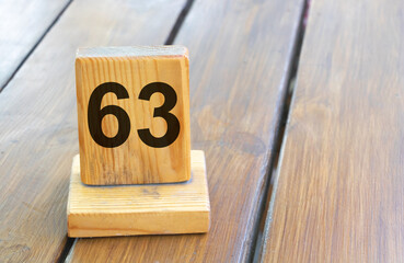 Wooden priority number 63 on a plank tab