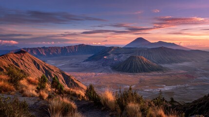 Scenic landscape of volcanic mountains against a sky with hues of pink orange and blue