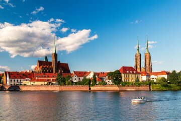 Panoramic view of Ostr&oacute;w Tumski with Cathedral of St. John the Baptist in Wroclaw, Poland, on a sunny day. Historic architecture, gothic churches and Odra river with a boat.