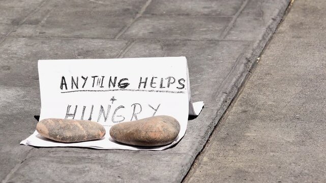 Homeless with anything helps and hungry sign on sidewalk 4k