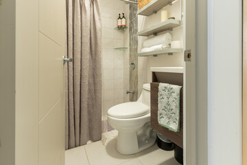 Obraz premium Modern small bathroom with floating shelves and gray shower curtain