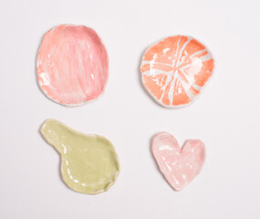 Four tiny colorful handmade clay saucers of different shapes, perfect for craft, pottery, art, home decor, tableware, or creative projects.
