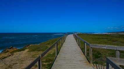 Obraz premium Wooden walkway on a cliff above the ocean