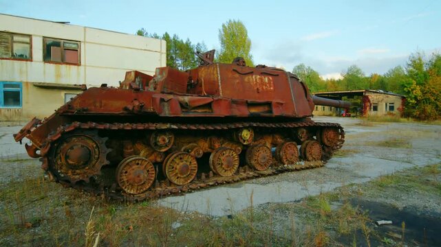 Footage capturing the eerie scene of a heavily rusted, abandoned Soviet ISU 152 self propelled gun within the Motor Transport Establishment ACT 2 in the ghost city of Pripyat, Ukraine.