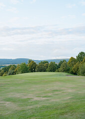 Fototapeta premium Scenic View of Lush Golf Course with Trees and Flags