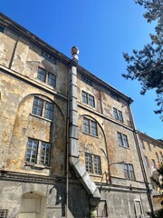 As I gaze upwards at a tall and impressive building, a vivid blue sky stretches out beautifully in the background, creating a stunning view