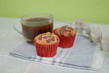 Plano horizontal de una mesa con dos pancakes con chispas de chocolate y una taza de café
