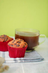 Imagen vertical con chispas de chocolate y una taza de café al fondo