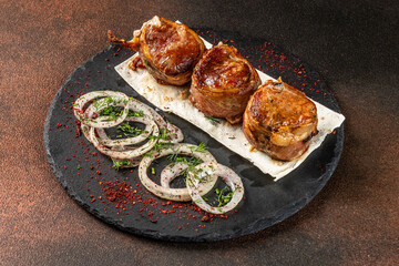 Pork medallions wrapped in bacon with onion and herbs