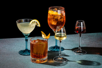 Assorted cocktails in elegant glasses on dark background