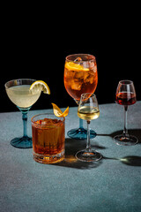 Assorted cocktails in elegant glasses on dark background
