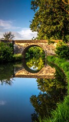 Fototapeta premium Stone arch bridge over canal (1)