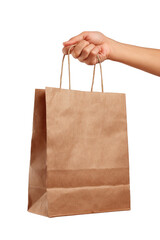 A hand holds the handles of a light brown paper bag