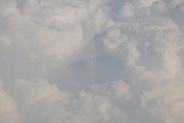 Soft, fluffy clouds fill the sky, creating a serene atmosphere with varying shades of white and...